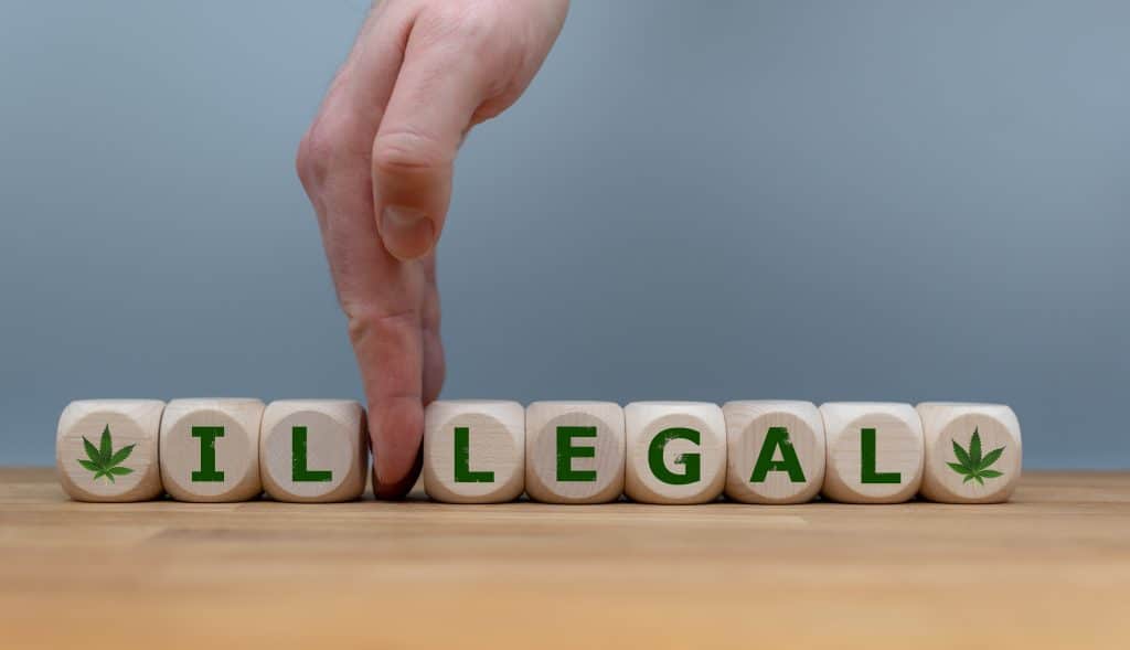 Symbol for Marijuana Legalization. Dice form the word "ILLEGAL" while a hand seperates the letters "IL" in order to change the word to "LEGAL".